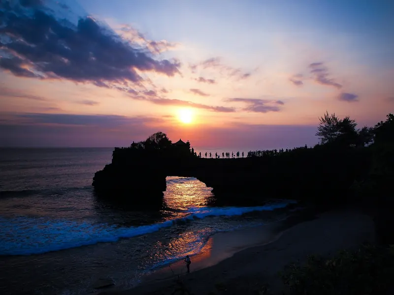 Golden Bali sunset through a rock arch